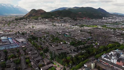 Cidade velha de Lijiang se estende em direção ao horizonte com colinas e céu azul