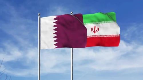 Qatar and Iran National Flags Waving Against Blue Sky
