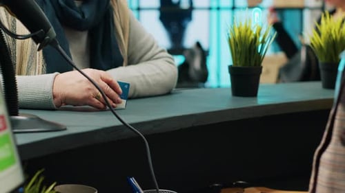 Senior Client Paying for Clothing Items at Store Checkout Counter