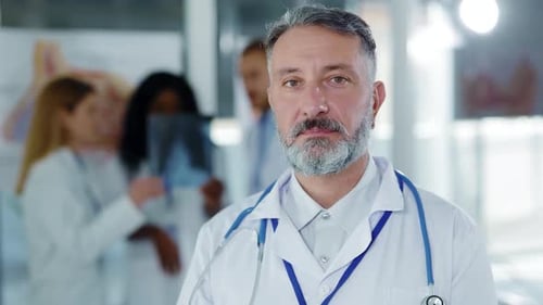 Medical professional portrait with team in background