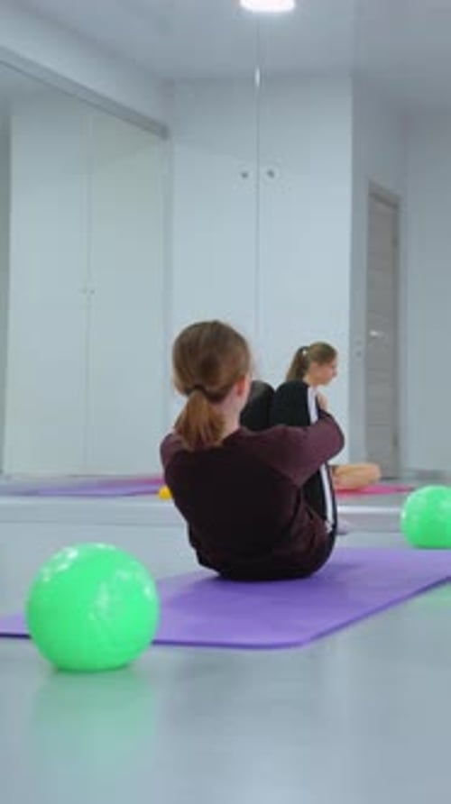 Group Workout with Instructor Oversight in Reflective Gym Setting