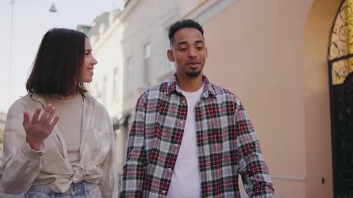 Multiethnic Couple in Love Walks Along the Narrow Streets of a European City The Guy and the Girl