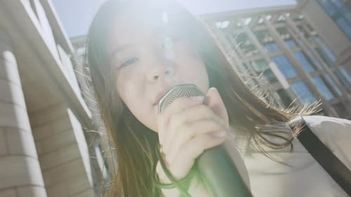 Youthful Singer Performing with Microphone in Urban Setting