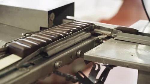 Producción en fábrica de chocolate de cuajada glaseada Vista de chocolates transportados en un transportador