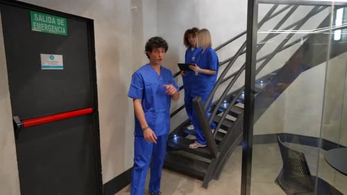 Medical team of doctors and nurses discussing patient case in hospital hallway