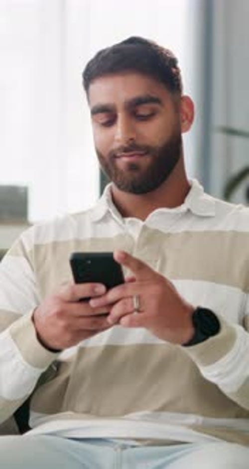 Phone, smile and reading with man on sofa for social media, text message and post comment
