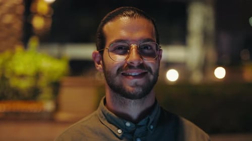 Handsome Guy Looking at Camera Standing in Night City Street Close Up