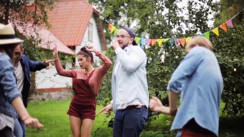 Leisure, Holidays, Fun And People Concept - Happy Friends Dancing At Summer Party In Garden