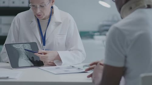 Doctor Showing X-Ray on Tablet at the Consultation in Clinic