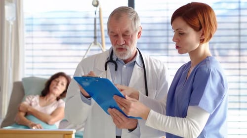 Senior Doctor Consults Nurse in Hospital