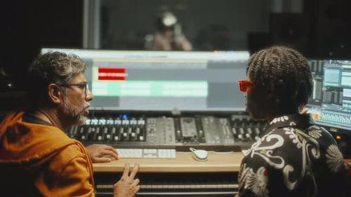 Music Producer and Sound Engineer Collaborating in Control Room