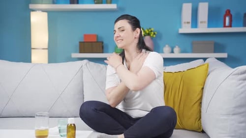 Woman Sits and Scratches Itchy Arm in Home