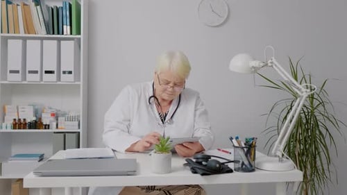 Woman doctor using tablet during working day at clinic.