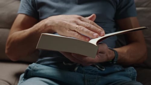 Close Up Shot of Man Reading Book at Home Turning Sheets
