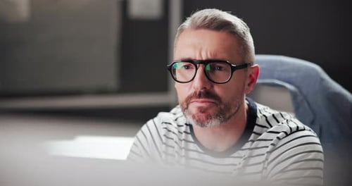 Adult Man Working at Computer Wearing Glasses
