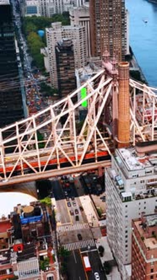 One of the waterfront sides of Queensboro Bridge with huge buildings surrounding it.