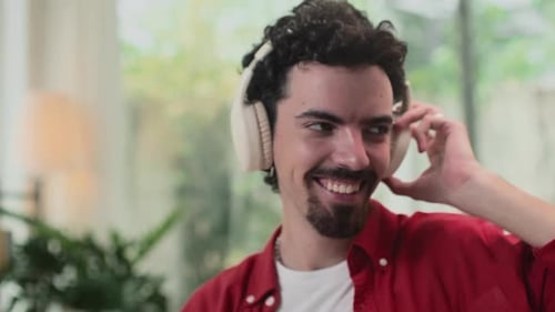 Man Smiling While Listening to Music with Headphones