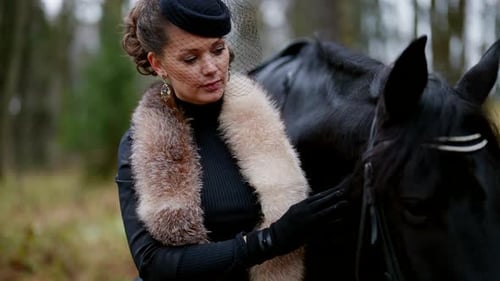 Une femme noble et un beau cheval noir dans le parc royal se promènent en automne, portrait de femme du XIXe siècle
