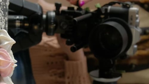 Woman Adjusts Video Camera on Tripod