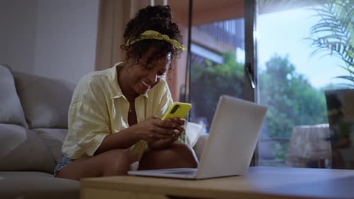 Smiling Woman Relaxing on Sofa Using Smartphone