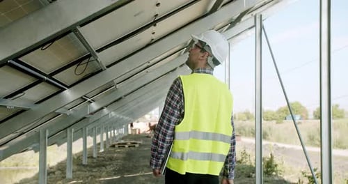 Männlicher Ingenieur inspiziert Sonnenkollektoren