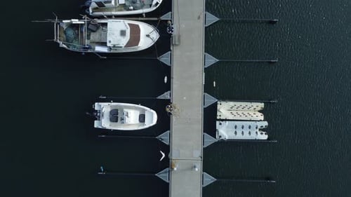 Aerial view from above over a jetty in the sea with a couple of boats