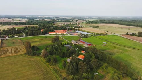 Aerial View of Rural Horse Stable Surrounded by Green Fields and Farmland