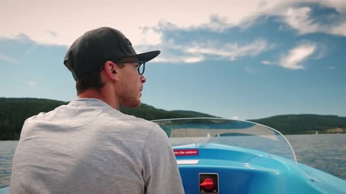 Man driving electric boat on lake