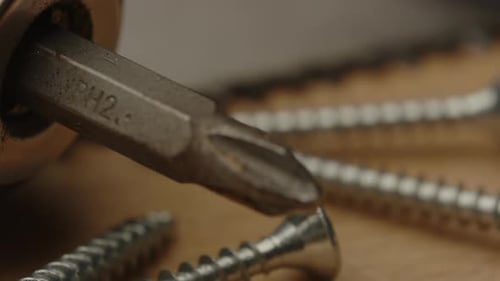 Soporte de enfoque, desde brocas de destornillador Electrónico hasta tornillos metálicos y sierra sobre una superficie de madera
