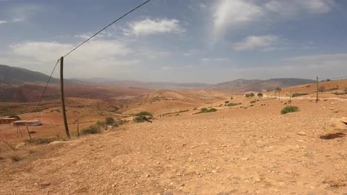 Arid Desert Landscape with Mountains and Blue Sky
