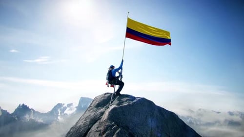 Alpiniste tenant le drapeau de la Colombie au sommet de la montagne