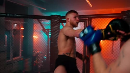 Boxers Sparring in an Enclosed Octagon Boxing Ring