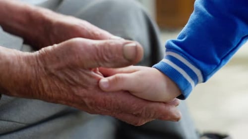 Child Hand Holding Older Person's Hand