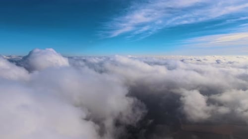Aerial View From High Altitude of Earth Covered with White Puffy Cumulus Clouds on Sunny Day