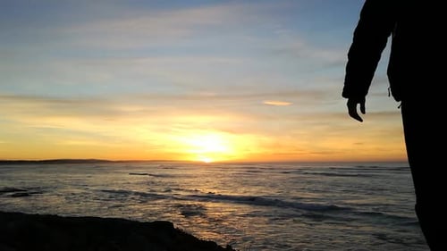 Silhouette adventure traveler admiring the view and sea sunrise