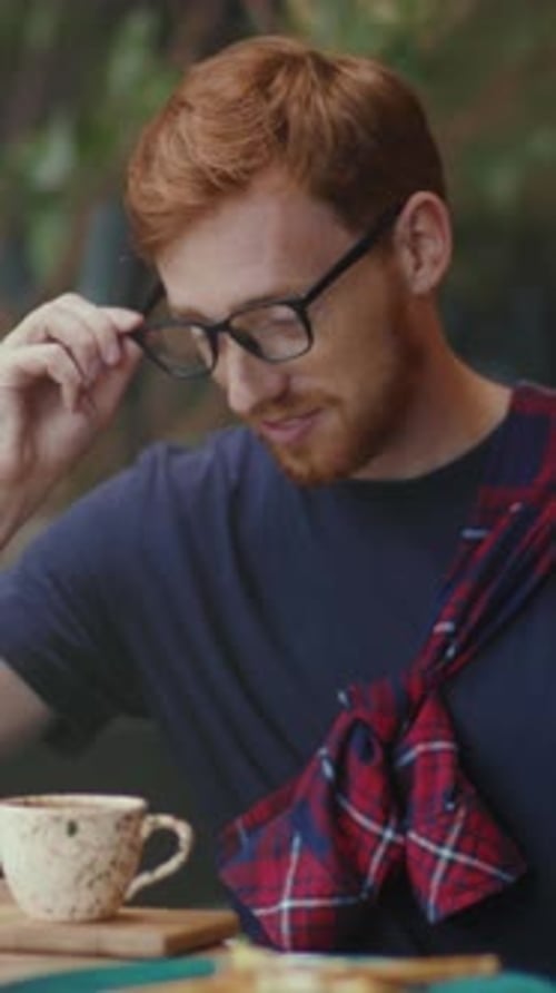 Man with Red Hair Enjoying Coffee in Cafe
