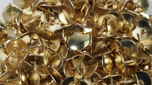 Shiny Gold Thumbtacks Clustered Together