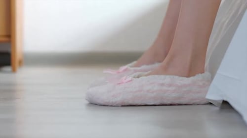 Une femme porte des pantoufles à la maison
