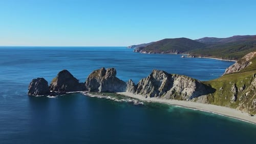 Aerial Cape with High Cliffs on a Sunny Day By the Sea Mountain Ridges