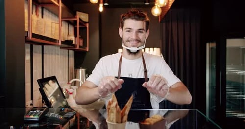 Young Adult Arranging Food at Cafe Counter