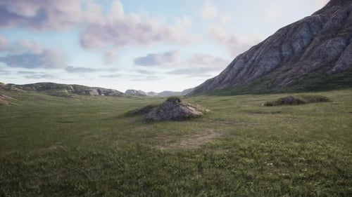 A Serene Mountain Landscape with a Vast Green Field in the Foreground