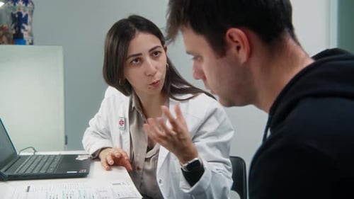 Doctor Explains Paperwork to Patient in Office