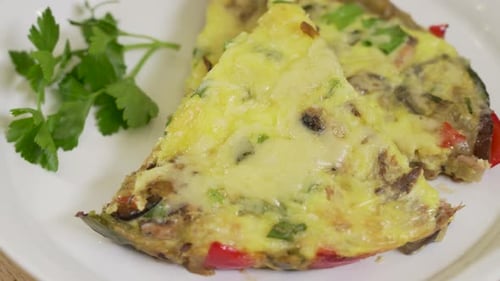 Tasty Omelet Slices with Fresh Herbs on Plate