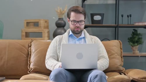 Man Working on Laptop Computer on Couch