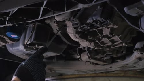 Auto Mechanic Inspecting Car from Underneath