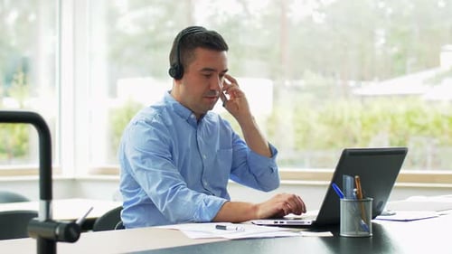 Man working at computer using a headset
