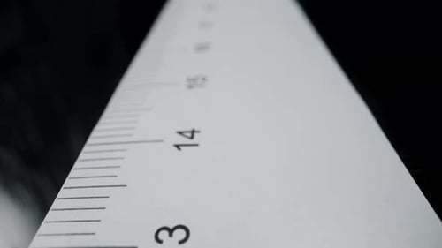 Schieben Sie am Lineal entlang, die Kamera stoppt bei fünfzehn Zentimetern und der Mann markiert mit einem Stift