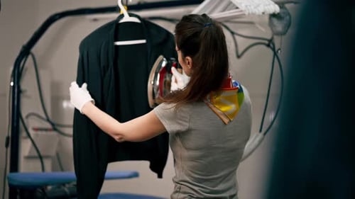 Woman Steaming a Jacket at the Dry Cleaner