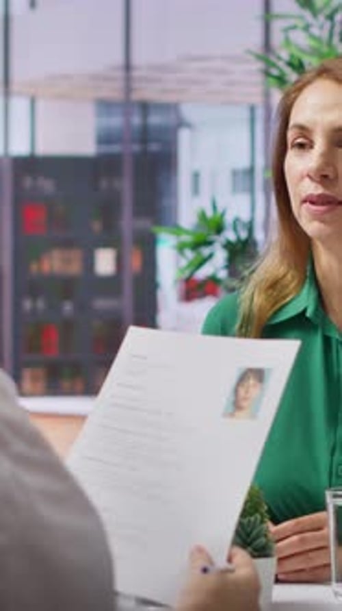 Vidéo verticale : un candidat présente son CV à un recruteur d'entreprise lors d'un entretien d'embauche structuré