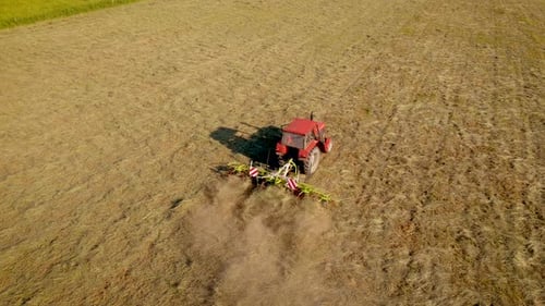 Trator Farmer on Hay Bale com Tedder movendo grama no campo para aeração e secagem mais rápida